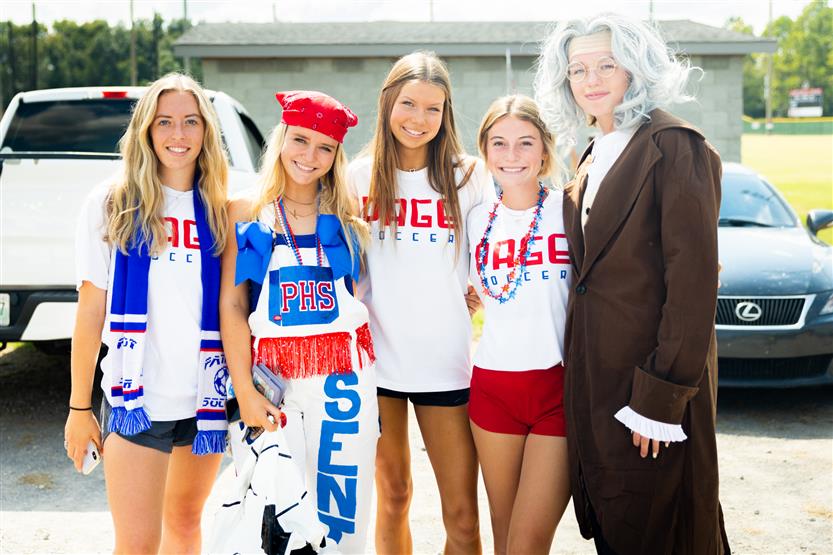 Five girls smile at a homecoming parade